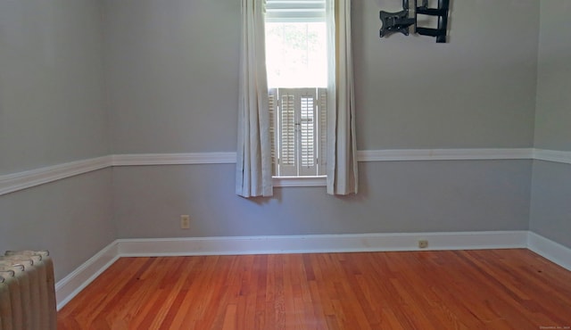 spare room featuring hardwood / wood-style flooring and radiator heating unit