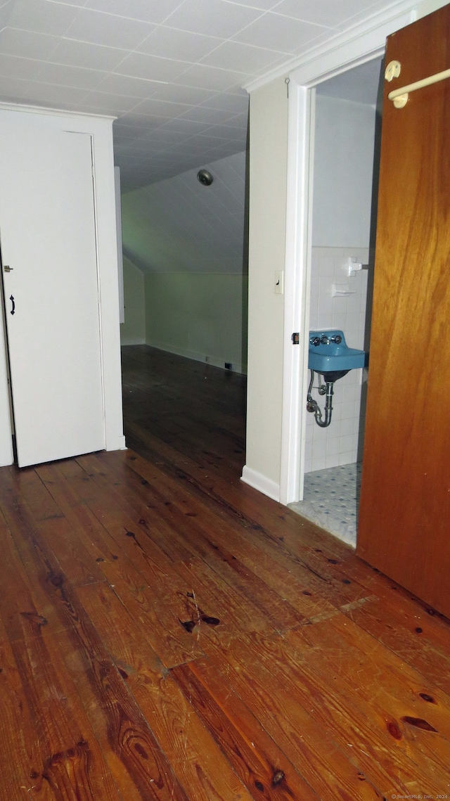 corridor with sink, tile walls, and wood-type flooring