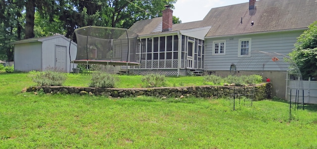 exterior space with a sunroom, a trampoline, a yard, and a storage shed