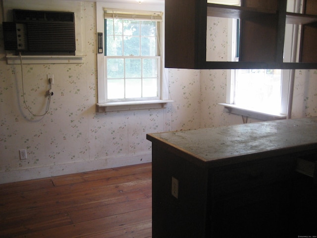 kitchen with light stone countertops, dark hardwood / wood-style flooring, and a wall mounted air conditioner