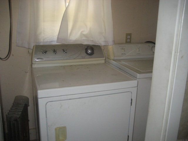 laundry room with washer and dryer and radiator heating unit