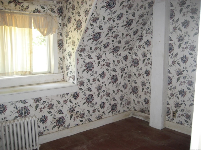 empty room with radiator and dark hardwood / wood-style flooring