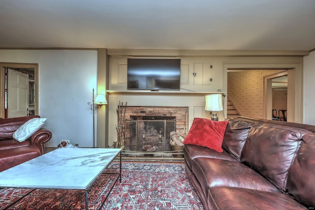 living room featuring a fireplace, ornamental molding, and hardwood / wood-style floors