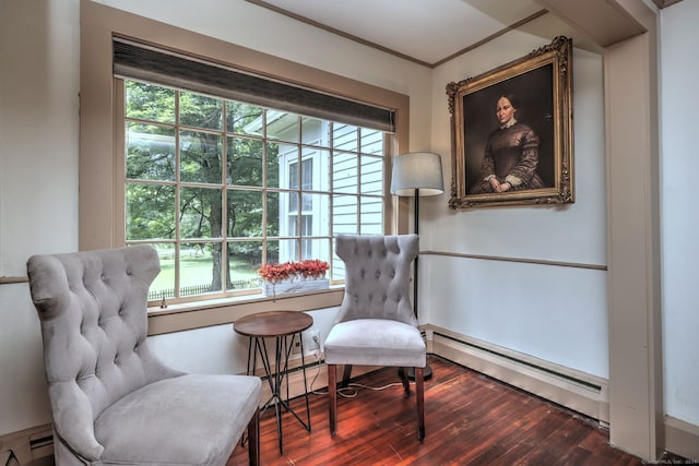 sitting room featuring a baseboard heating unit, hardwood / wood-style floors, and crown molding