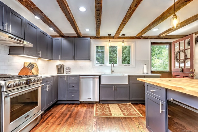 kitchen featuring stainless steel appliances, dark hardwood / wood-style flooring, beam ceiling, butcher block countertops, and backsplash