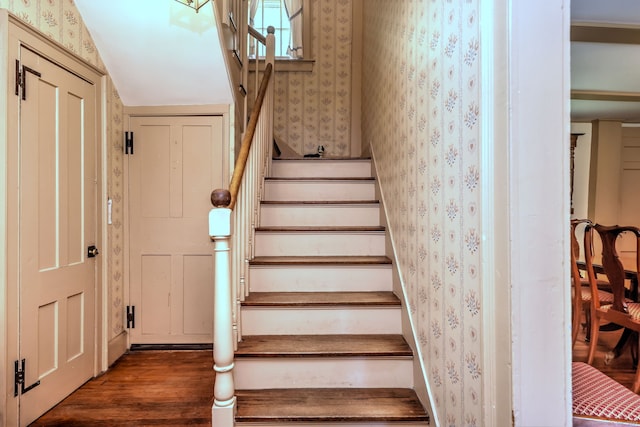 stairway with dark hardwood / wood-style floors and lofted ceiling