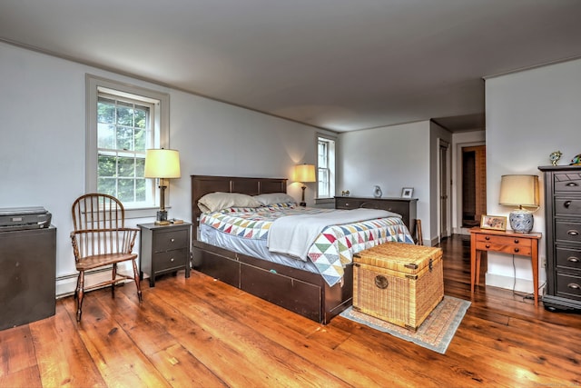 bedroom with hardwood / wood-style flooring and baseboard heating