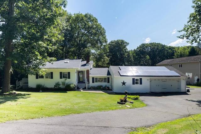 single story home featuring a garage, driveway, and a front lawn