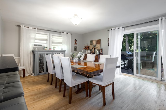 dining space featuring light wood-type flooring and cooling unit