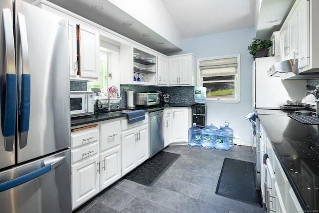 kitchen with white cabinetry, appliances with stainless steel finishes, and tasteful backsplash