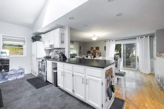 kitchen with dark countertops, white cabinetry, a peninsula, and stainless steel electric stove