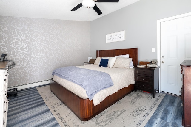 bedroom with a baseboard radiator, wood finished floors, and a ceiling fan