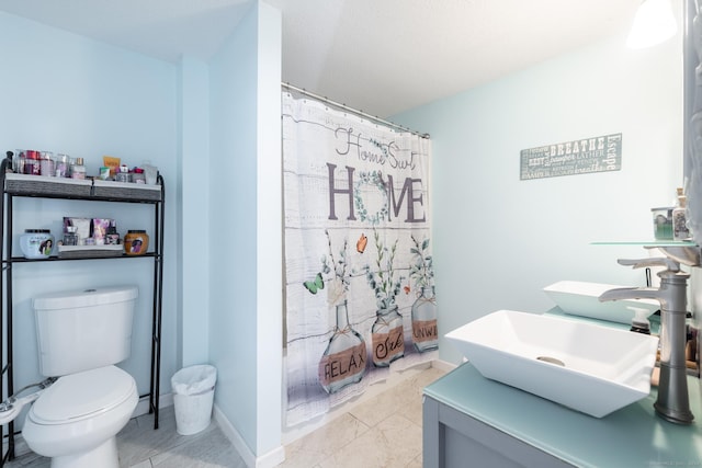 full bathroom with toilet, a shower with curtain, baseboards, and vanity