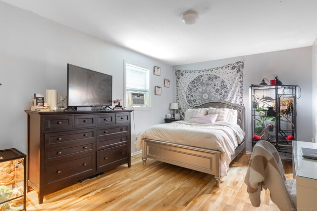 bedroom with light wood-type flooring and cooling unit