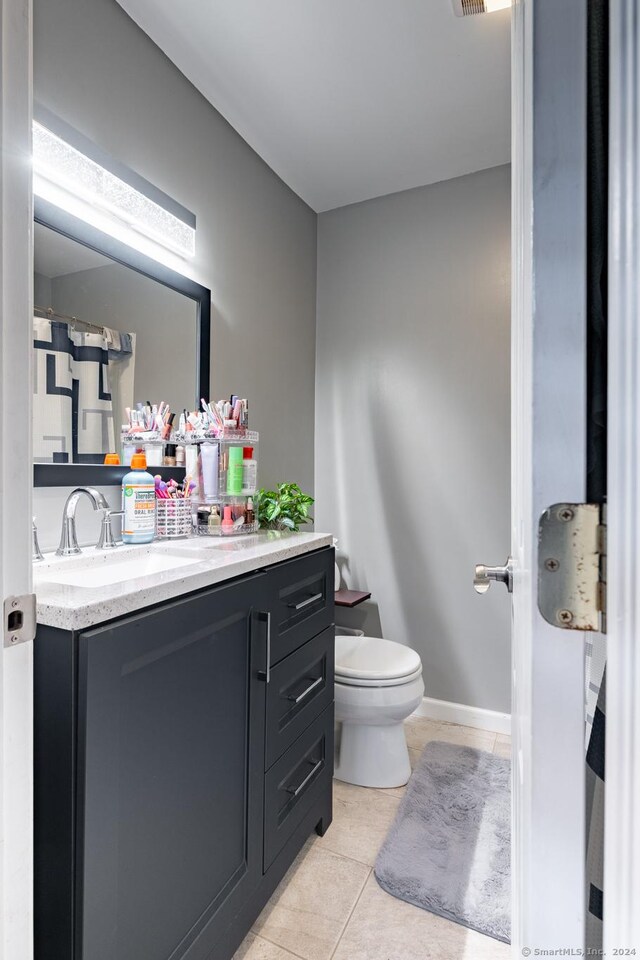 bathroom featuring toilet, visible vents, baseboards, vanity, and tile patterned floors