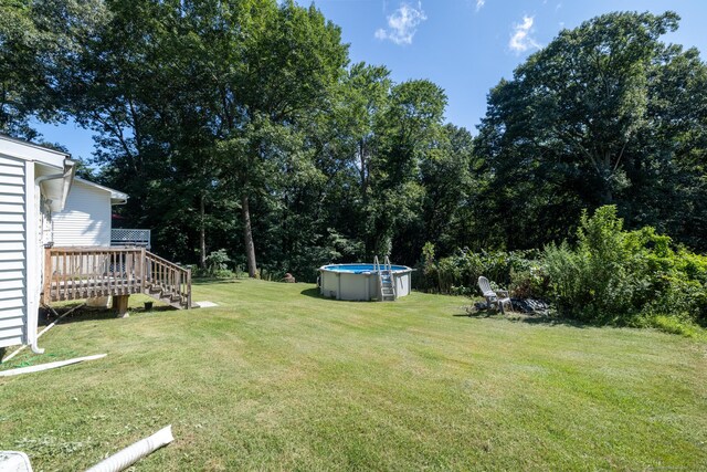 view of yard with an outdoor pool and a wooden deck