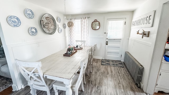 dining area with radiator heating unit and dark wood-type flooring