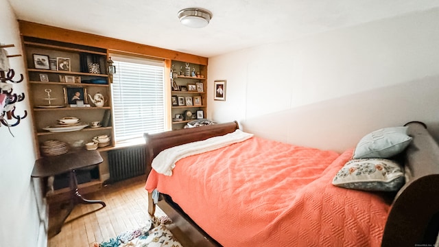 bedroom featuring hardwood / wood-style floors and radiator