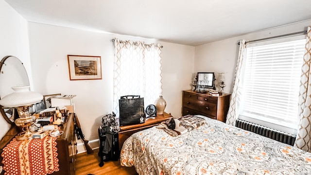 bedroom with radiator heating unit and hardwood / wood-style floors