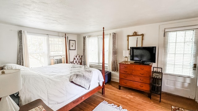 bedroom with hardwood / wood-style flooring and cooling unit