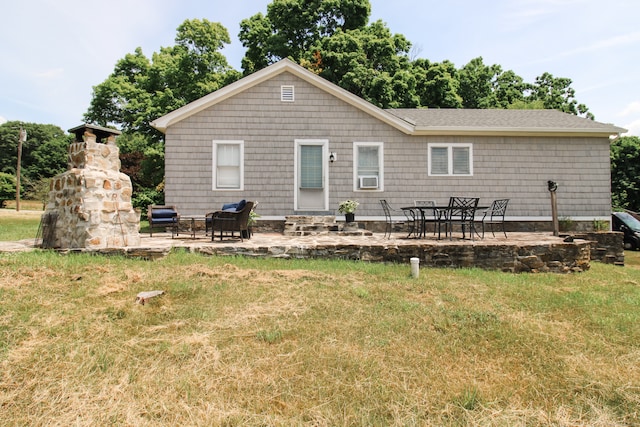 exterior space featuring a stone fireplace, a patio, and a lawn