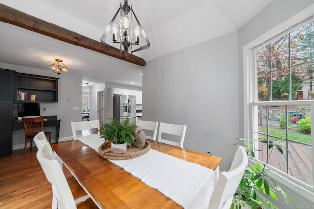 dining space featuring vaulted ceiling with beams, a chandelier, and wood-type flooring