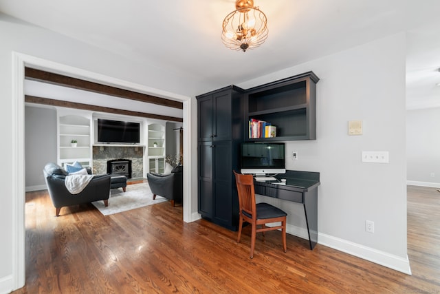 office with built in features, beamed ceiling, and dark hardwood / wood-style floors