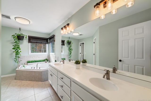 bathroom with tiled tub, tile patterned flooring, and vanity