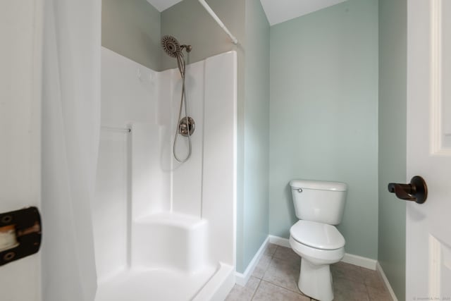 bathroom featuring tile patterned floors, a shower, and toilet