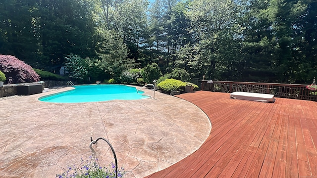 view of swimming pool with a diving board and a wooden deck