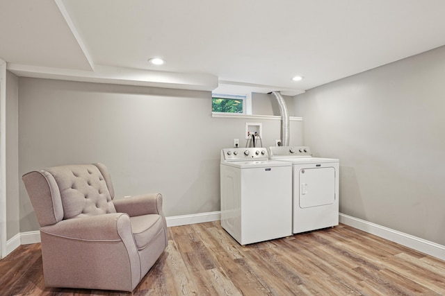 clothes washing area featuring baseboards, laundry area, light wood-type flooring, and washer and dryer