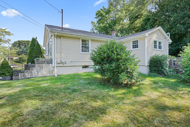 rear view of property featuring a yard and a chimney