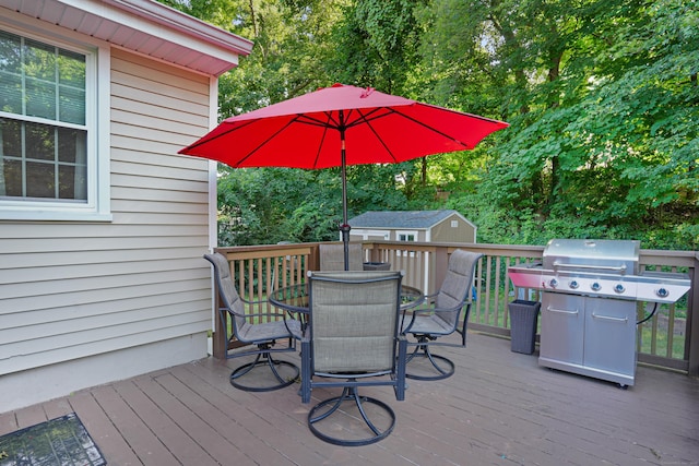 wooden deck featuring an outbuilding, a storage unit, and outdoor dining area