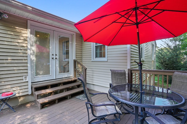 wooden deck with entry steps, french doors, and outdoor dining space