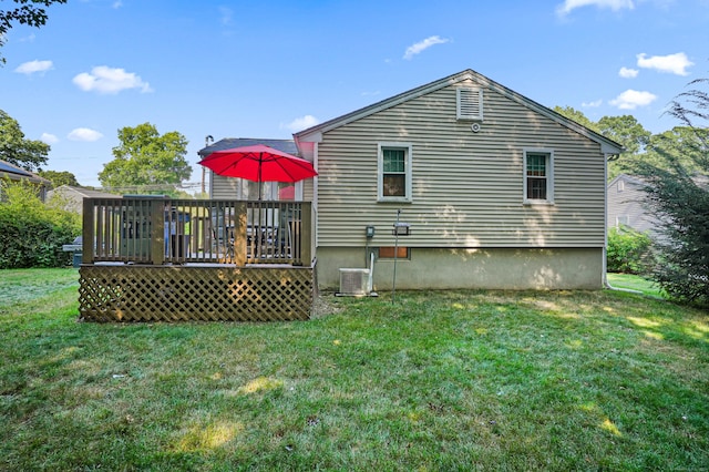 rear view of house with a lawn and a wooden deck