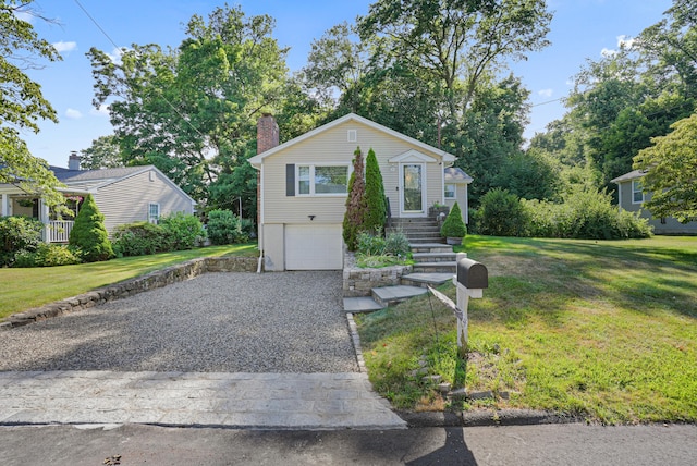 view of front of home featuring driveway, a garage, a chimney, and a front lawn