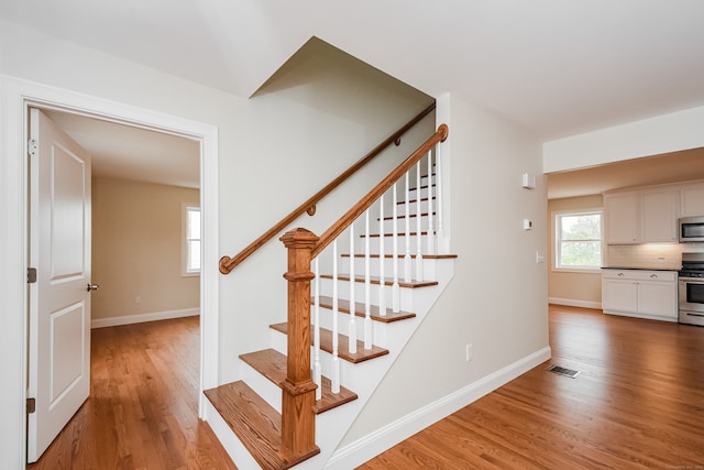 staircase with hardwood / wood-style floors