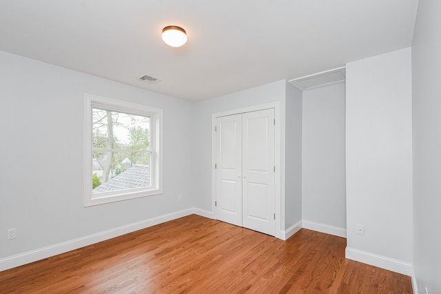 unfurnished bedroom featuring a closet and wood-type flooring