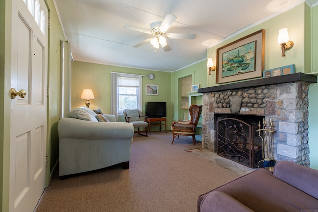 carpeted living room featuring a fireplace, ceiling fan, and crown molding