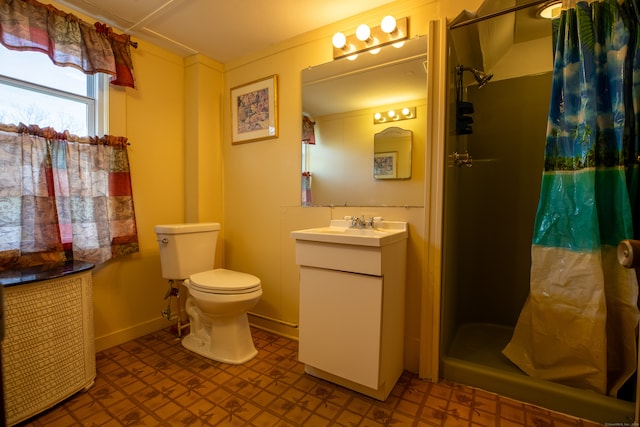 bathroom with tile patterned flooring, curtained shower, toilet, and vanity