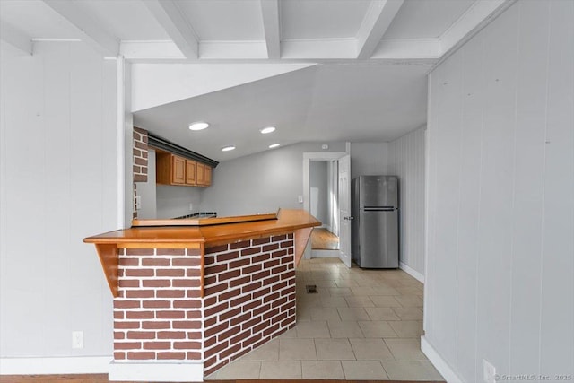 bar with light tile patterned floors, beam ceiling, and stainless steel refrigerator