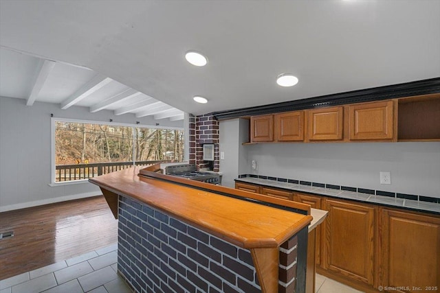 bar with light tile patterned floors, beamed ceiling, and range