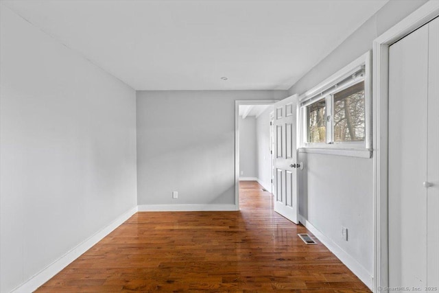 empty room with dark hardwood / wood-style flooring