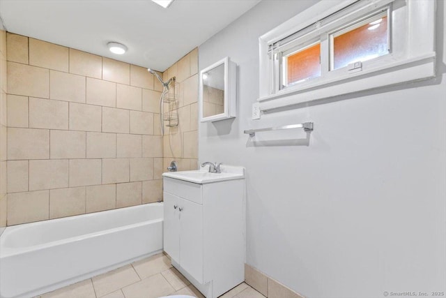 bathroom featuring tile patterned flooring, tiled shower / bath combo, and vanity