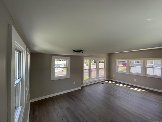 unfurnished room with dark hardwood / wood-style flooring