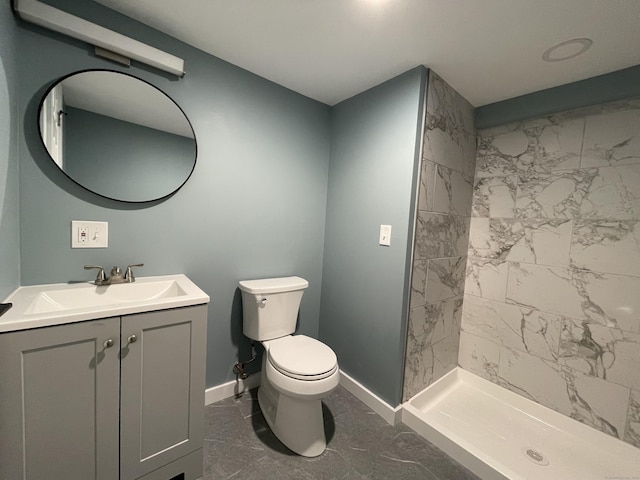 bathroom featuring tiled shower, vanity, and toilet