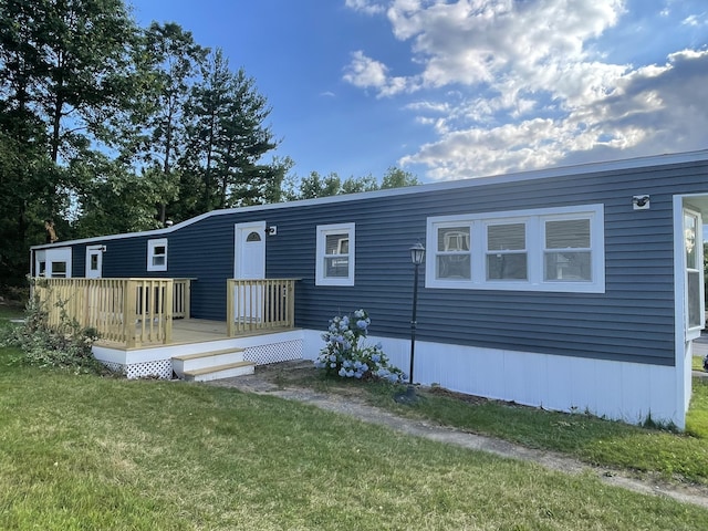 manufactured / mobile home with a front yard and a deck