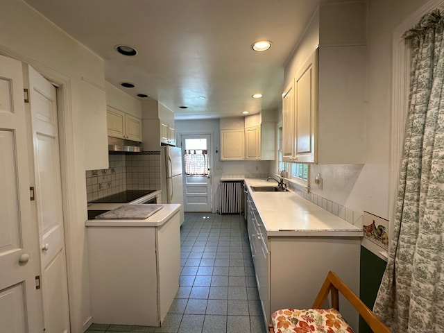 kitchen featuring light tile patterned floors, black electric stovetop, decorative backsplash, white refrigerator, and sink