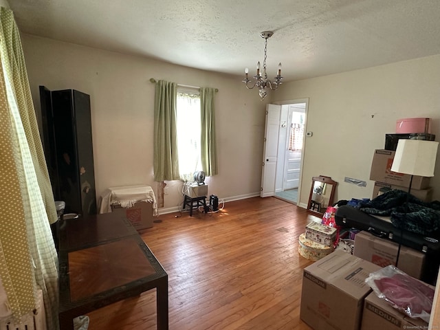 living room with a notable chandelier, a textured ceiling, and hardwood / wood-style floors