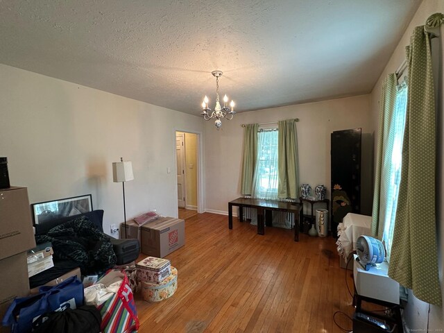 interior space featuring an inviting chandelier, a textured ceiling, and hardwood / wood-style flooring